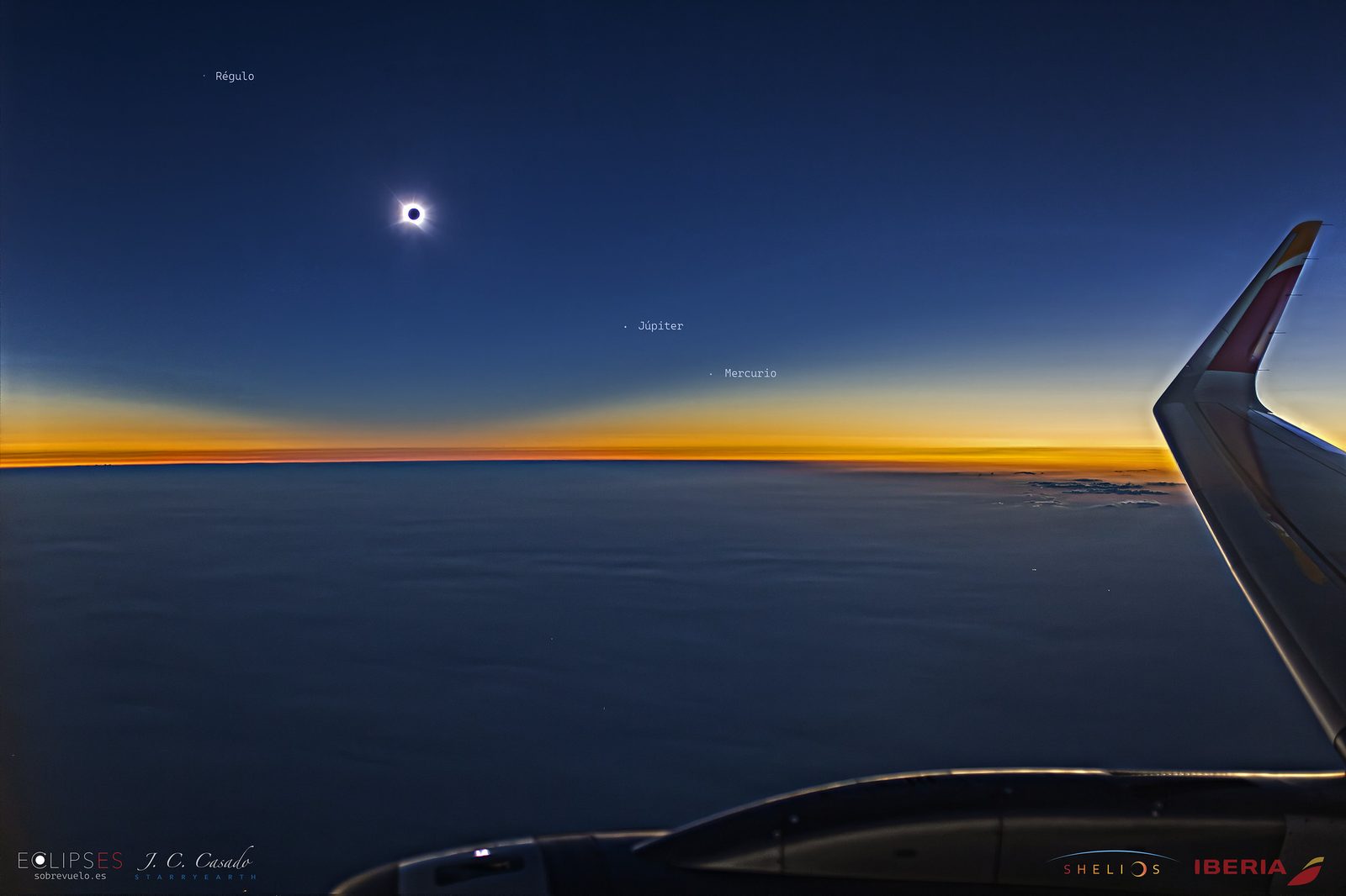 La totalidad del eclipse vista desde la ventanilla del vuelo IB1473, con el ala de Iberia y la banda crepuscular sobre el horizonte